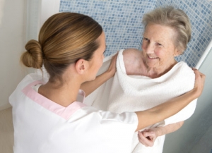 caregiver assisting old woman in bathing